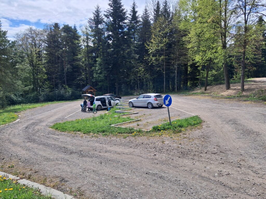 Leśny parking na przełęczy pod Ciecniem – kilka samochodów i chatka przy wjeździe