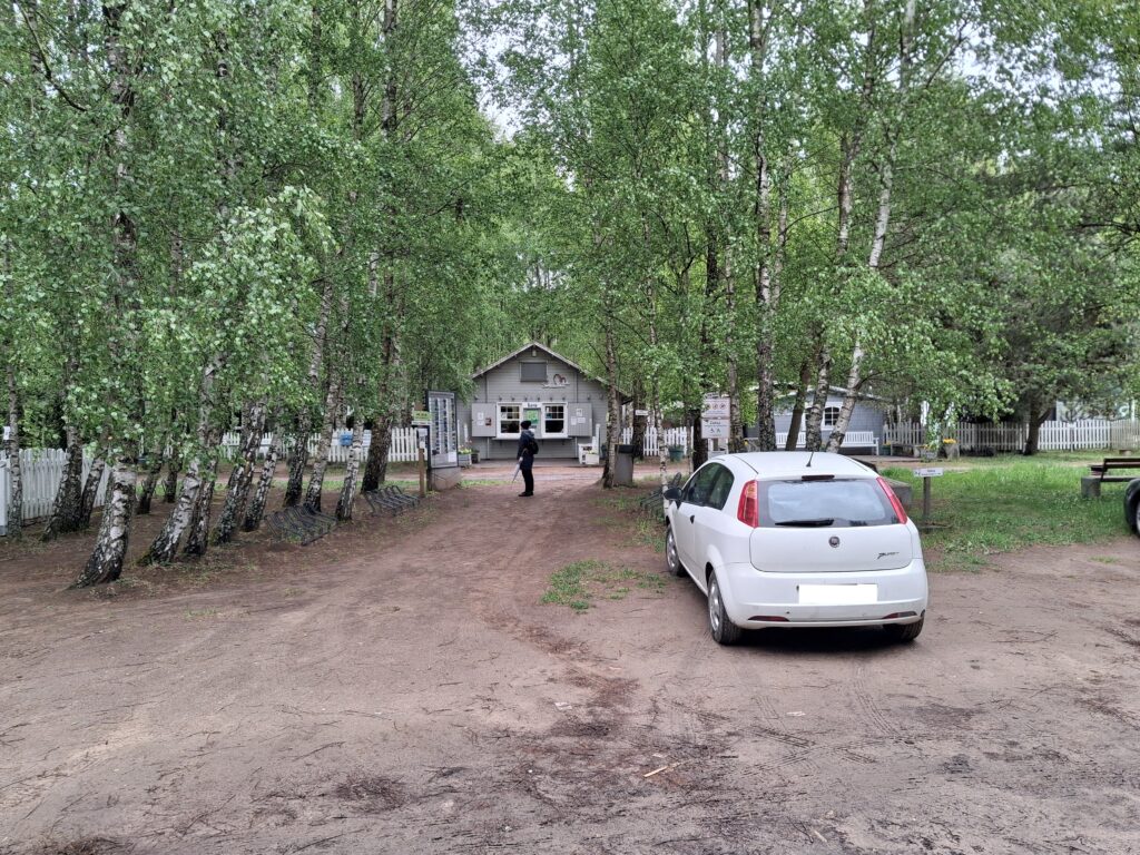 Wejście do Hortulus Spectabilis w Dobrzycy – parking i budynek kasy wśród brzóz