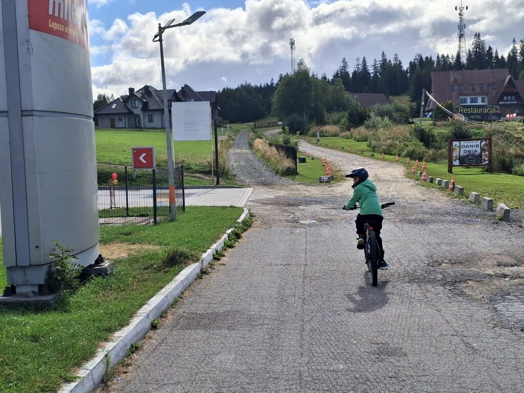 Syn na rowerze na starcie trasy na Turbacz w Rdzawce